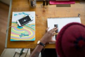 Student in a hat using a ruler with Dr. Seuss's Oh The Places You'll Go